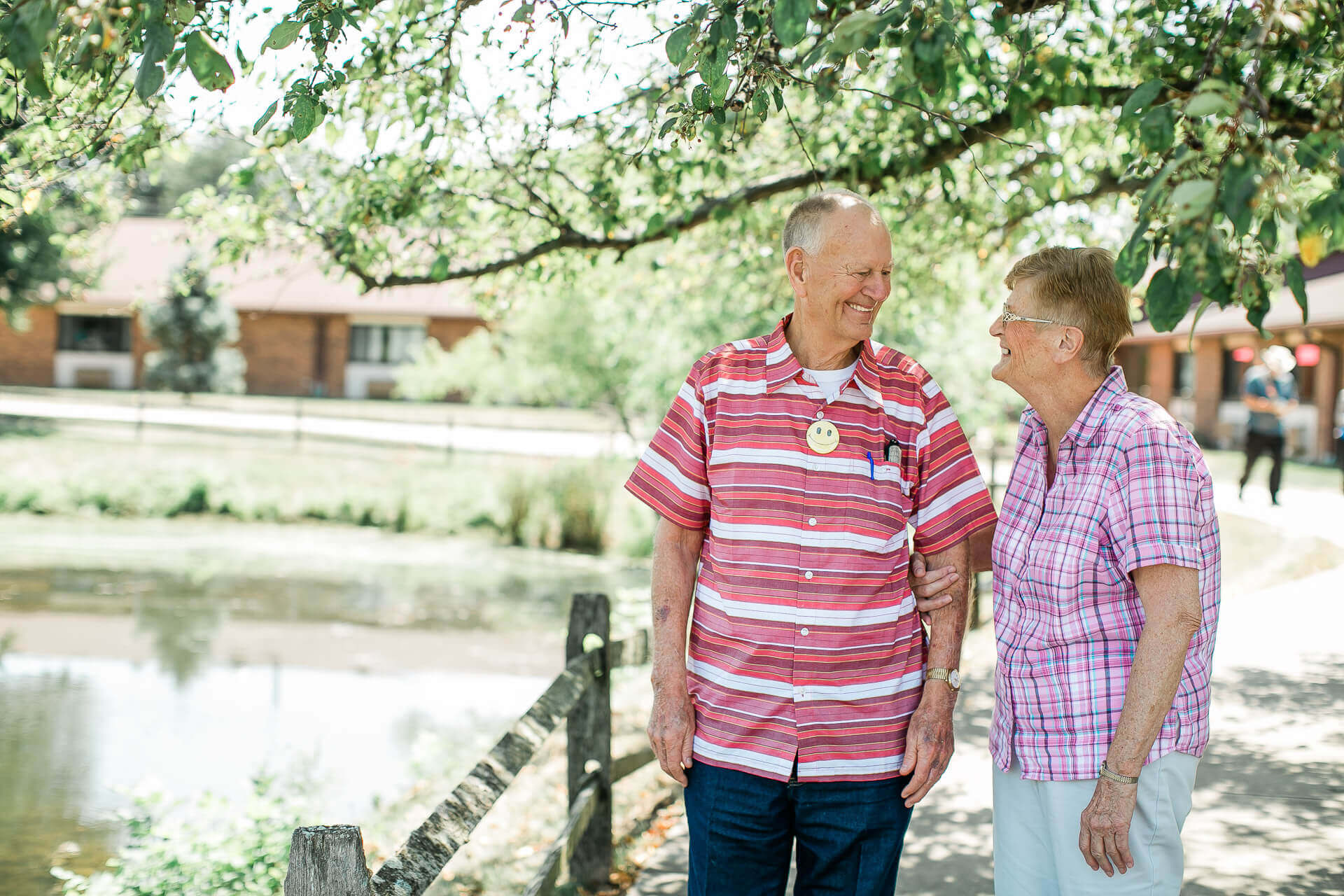 Two smiling seniors enjoying a moment by the water.