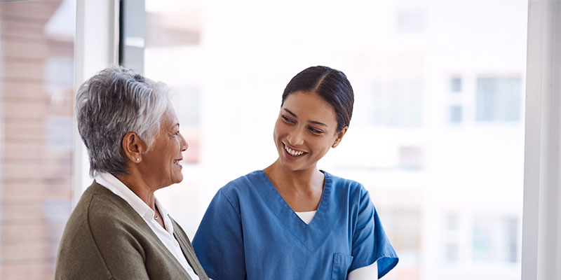 A nurse and patient sharing a warm conversation.