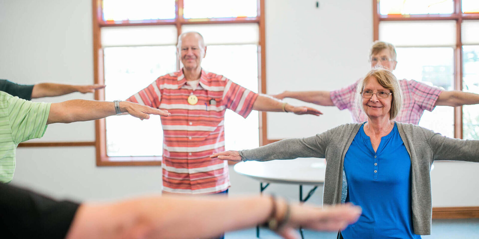 Seniors participating in a group activity with outstretched arms.