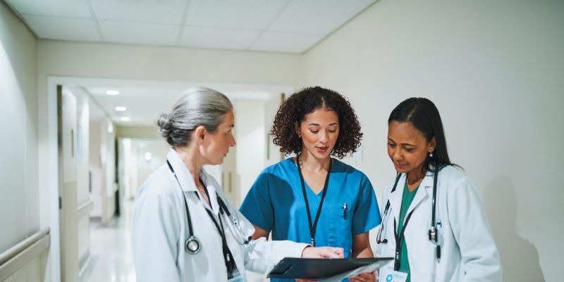 Doctors and nurses discuss paperwork in a hallway