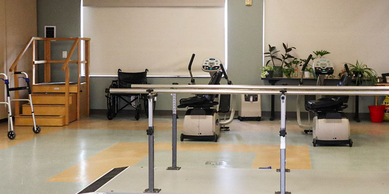 Physical therapy room with equipment and rehabilitation tools.